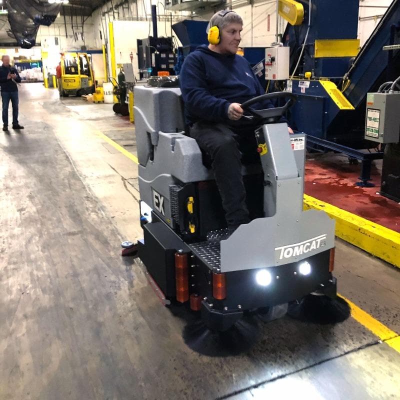 Tomcat Ride On Floor Scrubbers EX production areas concrete A Tomcat EX rider auto scrubber cleaning the concrete floor of a production area at a recycler in Gary, IN