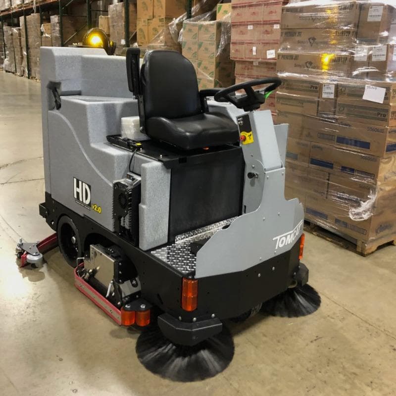 Tomcat Ride On Floor Scrubbers EX warehouse concrete A FactoryCat Micro-HD battery floor scrubber cleaning the concrete floor of a crowded warehouse in Philadelphia, PA