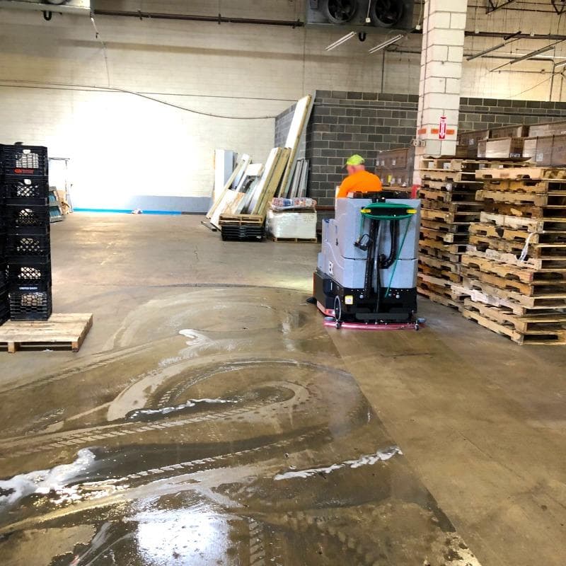 Tomcat Ride On Floor Scrubbers EX warehouse concrete A Tomcat EX ride on battery floor scrubber cleans the concrete floor of a food distributor warehouse in Dayton, OH