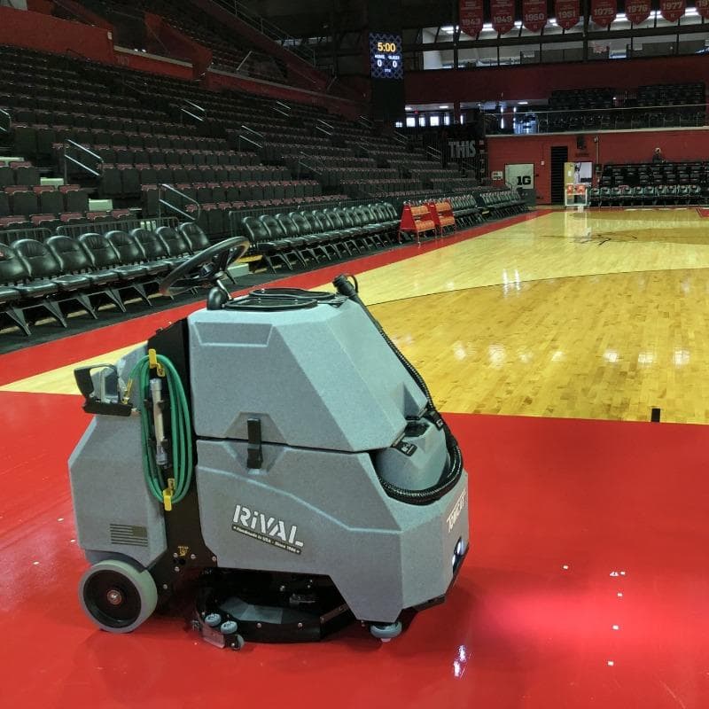 Tomcat Stand On Floor Scrubbers Rival courts gym floors A Tomcat Rival Stand On floor scrubber cleans the wood floor on a basketball court in a university arena in Delaware.