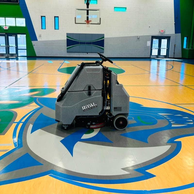 Tomcat Stand On Floor Scrubbers Rival gymnasium wood gym floor A Tomcat Rival stand on battery floor scrubber cleaning the wood gym floor  of a gymnasium in Pheonix, AZ