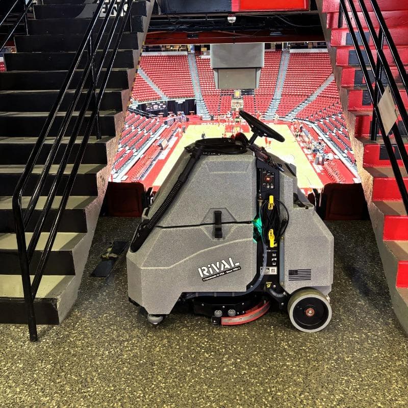 Tomcat Stand On Floor Scrubbers Rival sports arena epoxy A Tomcat Rival stand on battery floor scrubber cleaning the epoxy floor of a university arena.