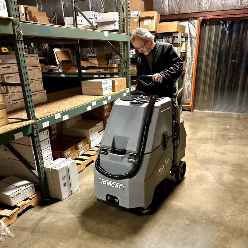 Tomcat Stand On Floor Scrubbers Rival warehouse concrete A Tomcat Rival Stand On Floor Scrubber cleans the concrete floor in the warehouse of a Normal,  Illinois cleaning and janitorial supply house