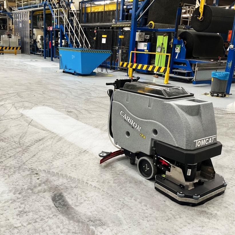 Tomcat Walk Behind Floor Scrubbers Carbon production floor epoxy floors A Tomcat Carbon walk behind battery scrubber drier cleaning the epoxy floor at a manufacturing plant in the Netherlands.