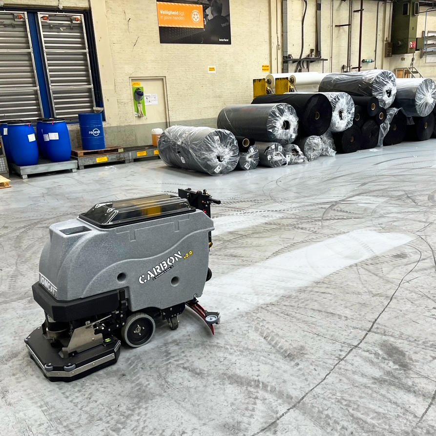 Tomcat Walk Behind Floor Scrubbers Carbon production floor epoxy floors A Tomcat Carbon walk behind battery scrubber drier cleaning the epoxy floor at a manufacturing plant in the Netherlands.